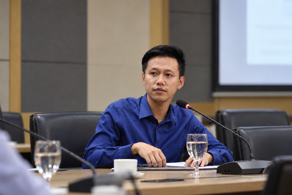 AI-edited portrait of Mr. Chai seated at a table in a realistic conference room